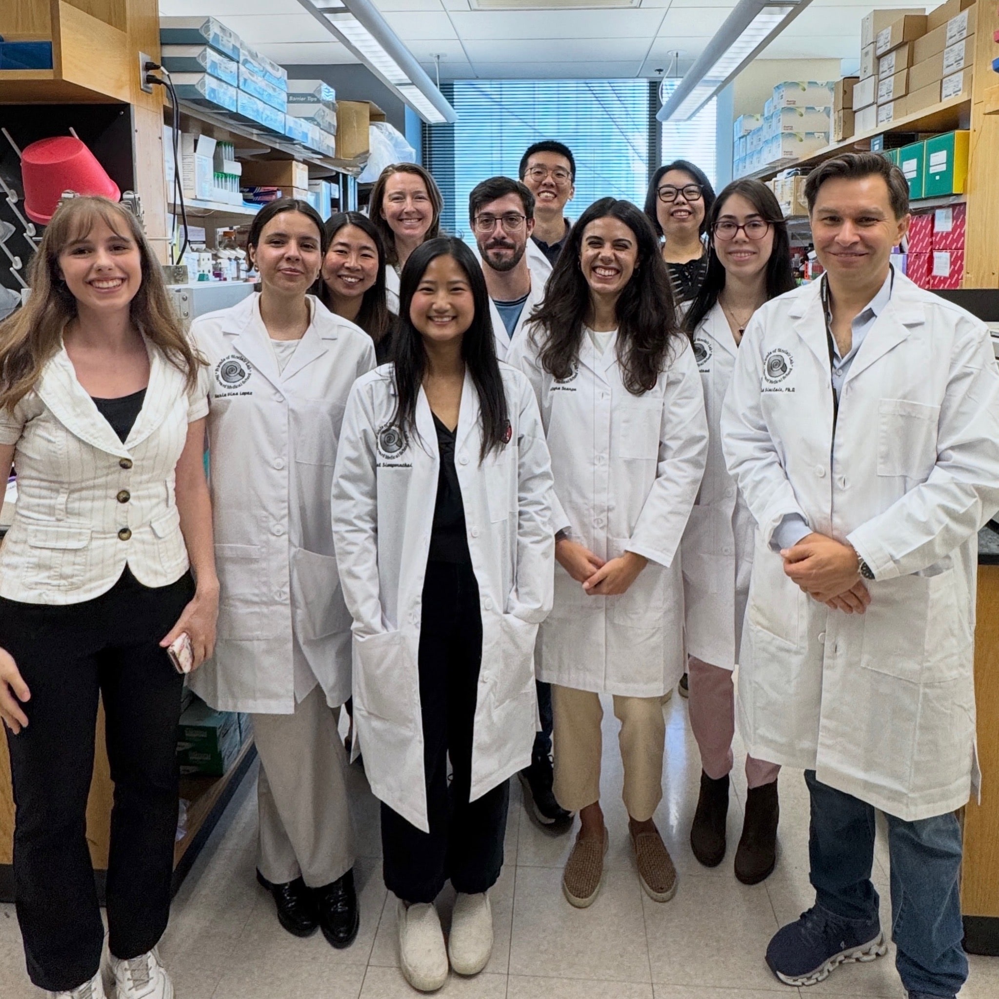 Members of the Sinclair Lab gathered in white lab coats